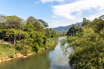 Fototapeta na wymiar The Mahaweli River flowing along the Royal Botanical Gardens, Peradeniya, Central Province of Sri Lanka