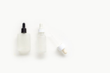 Fototapeta na wymiar Serum bottles on white background. Cosmetic flatlay