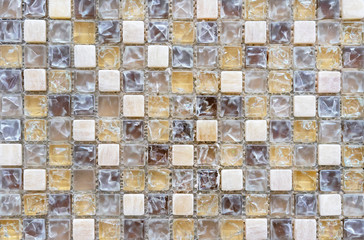 Keramische mozaïektegels met bruine, grijze en witte vierkanten.