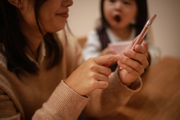 スマートフォンの操作に夢中になる母親