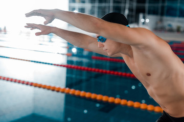 handsome and muscular swimmer in goggles with outstretched hands