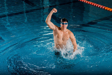 excited swimmer in goggles celebrating triumph