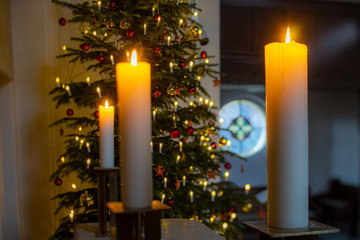 warmer, softer Kerzenschein und Lichterglanz im Altarraum einer Kirche mit Weihnachtsbaum