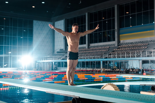 muscular swimmer standing with outstretched hands