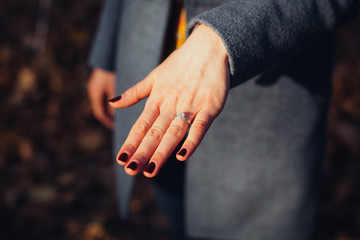 Young woman showing her hand with an engagement ring on it.