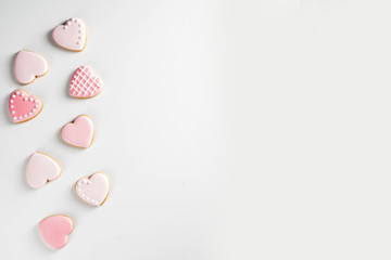 Homemade pick sugar glazed Valentine day cookies. Valentine heart shaped bakings. White stone...
