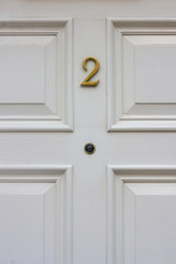 House number 2 on a white wooden front door