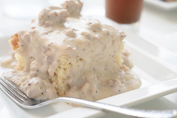 Square biscuit covered with sausage gravy and a Bloody Mary cocktail