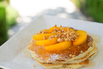 Pancakes covered in peaches and granola 