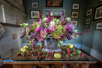 Fototapeta na wymiar Beautiful green pink and purple flower arrangement in autumn colors in a castle setting