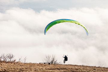 paraglider starting to paragliding above mountain