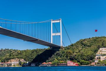 Beautiful view of Bosphorus bridge cross the Bosphorus strait with Turkish National flag, Istanbul, Turkey, view on a cruise ship sailing on the  Bosphorus strait