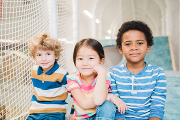 Cute restful boys and girl of Asian, Caucasian and African ethnicities