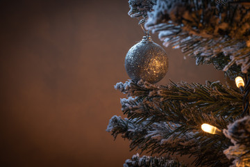 SILVER BALL IN SNOWY CHRISTMAS TREE WITH LIGHTS