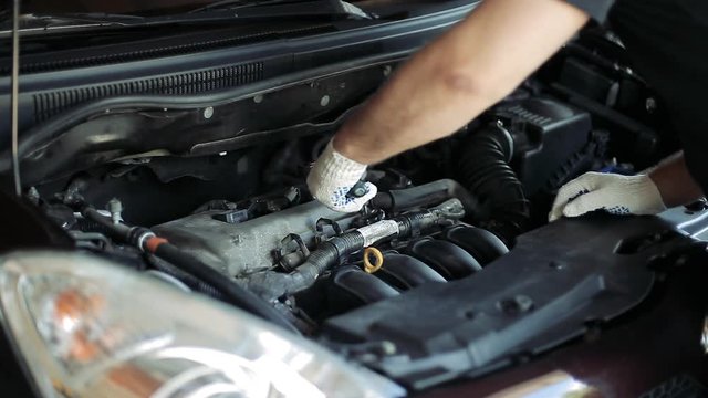 Auto mechanics use a socket wrench to unscrew parts under the hood of a car
