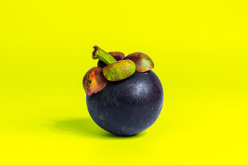 Mangosteen isolated on yellow background. Mangosteens, the famous delicious fruit from Thailand, In Asia it also known as The Queen of Fruits.