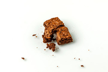 Frischgebackene Brownies angebissen auf weißen Hintergrund
