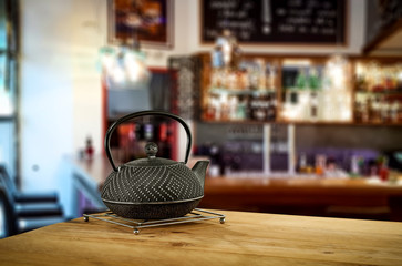 Kettle on wooden board and cafe interior.Free space for your decoration. 