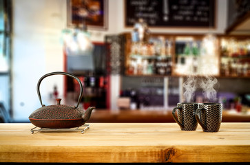 Kettle on wooden board and cafe interior.Free space for your decoration. 