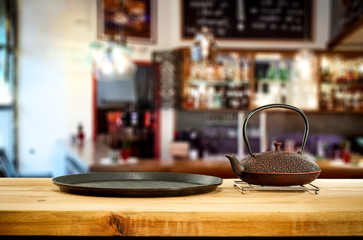 Kettle on wooden board and cafe interior.Free space for your decoration. 