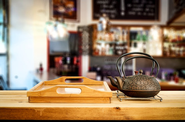 Kettle on wooden board and cafe interior.Free space for your decoration. 