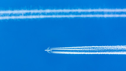 Four engined airplane during flight in high altitude with condensation trails