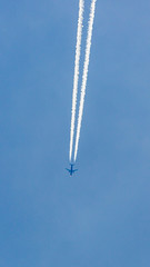 Two engined airplane during flight in high altitude with condensation trails