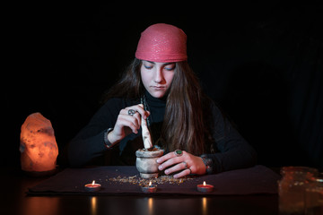 Caucasian witch mixing different herbs to make a spell or natural treatment