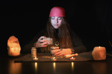 Caucasian witch mixing different herbs to make a spell or natural treatment