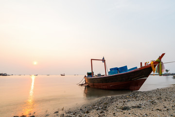 Naklejka na ściany i meble Beautiful seascape sunset with fishing boat long exposure