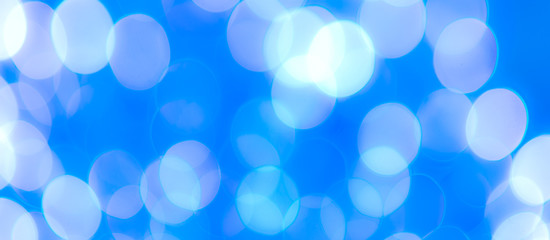 Fototapeta premium Abstract Bokeh Blue and green background of defocused glittering lights. Christmas, Party, New Year, luxurious background pattern concept. banner.