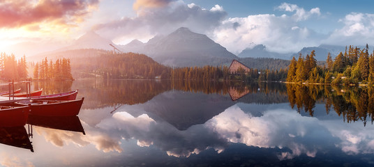 Incredible Nature Landscape. Beautiful view of traditional wooden boats on  Strbske Pleso Lake...