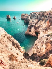 Fototapeta premium The famous cliffs and rocks in the ocean from a viewpoint over the ocean at sunset light. Perfect spot for travel ideas in europe. Farol da Ponta da Piedade, Lagos, Faro, Portimão, Algarve, Portugal