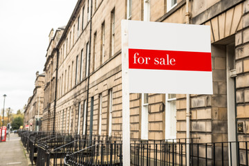 Sign outside an old terraced house on sale in a city centre on a cloudy autumn day. Edinburgh, Scotland, UK.