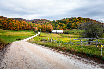 Unpaved road to a farm in a rolling rural landscape on a cloudy autumn morning. Beautiful autumn...