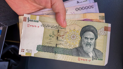 Hand holding Iranian Rial.