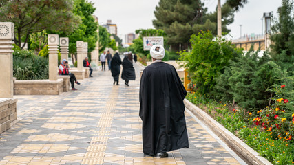 Iranian man walking in a street in the sacred city of Qom, Iran