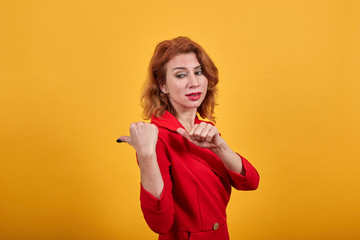 Disappointed caucasian young woman wearing fashion red jacket over isolated orange background...