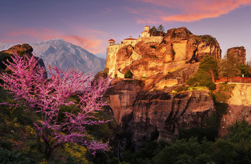 Scenic image of spring Landscape Monastery Meteora Greece. Stunning spring panoramic landscape. View at mountains and blossoming trees during sunrise. Wonderful nature scene