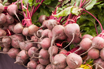 Pile of red beets with greens at farmers market