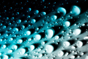 Drops of water with a beautiful smooth gradient closeup macro on the material in the sunlight.