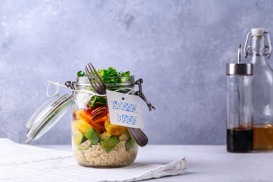 Homemade salad in glass jar with quinoa and vegetables with label lunch time no plastic and take away concept