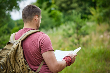 young man with map and backpack