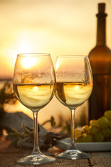 two glasses with wine during sunset time