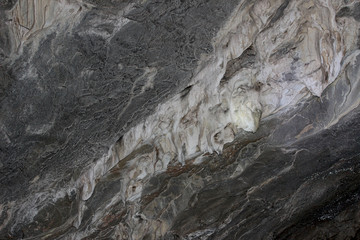 Gray karst cave. Rock formations in the cave, stalactites and stalagmites. Abstract gray grunge background. Stone texture background. Spotted abstract stone. Russia, Bashkortostan, a fairy cave
