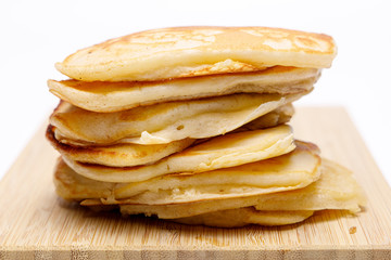 Stapel Pancakes auf einem Bambus Brettchen ohne Sirup, isoliert auf Weißen Hintergrund