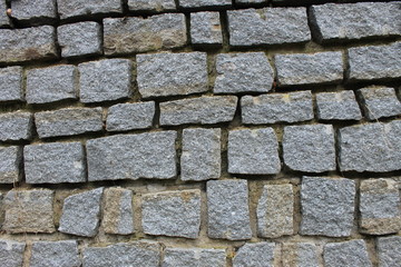 The texture of the stone walls of the old city of Europe, bricks made of granite and stones.