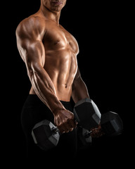 Fototapeta na wymiar Close-up of handsome power athletic mans hand in training pumping up muscles with dumbbell. Strong bodybuilder with six pack, perfect abs, shoulders, biceps, triceps and chest