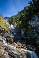 Fototapeta na wymiar kuhflucht waterfall with sky in forest long exposure alps germany