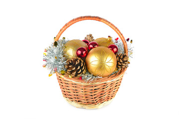 Christmas ornaments and pine cones in a wicker basket isolated on white background.